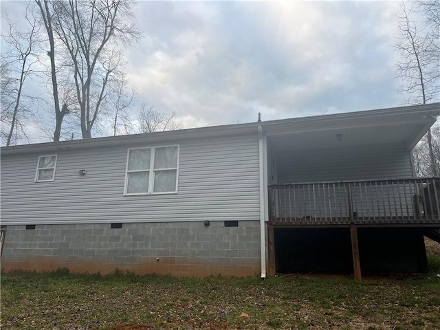 view of side of home with crawl space and a wooden deck