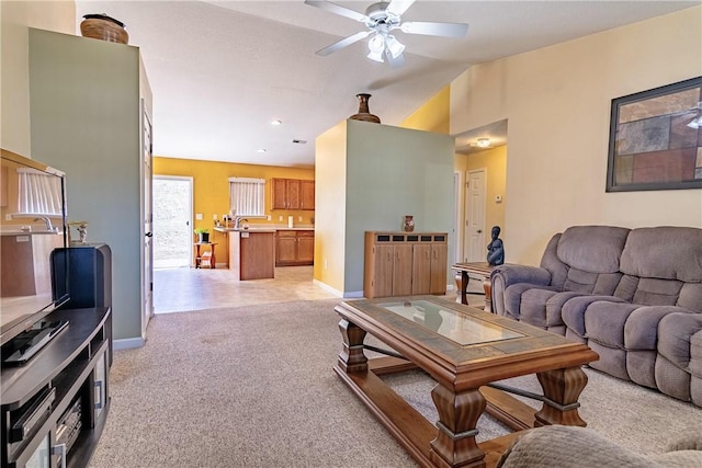 living room with light carpet, baseboards, ceiling fan, and vaulted ceiling