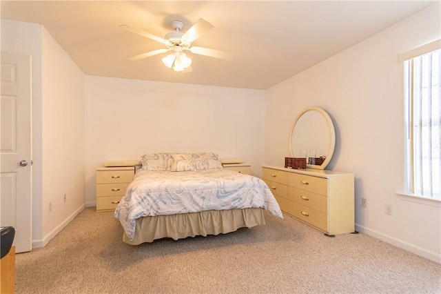 bedroom with light colored carpet, baseboards, and ceiling fan