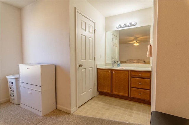 bathroom with baseboards, vanity, and ceiling fan