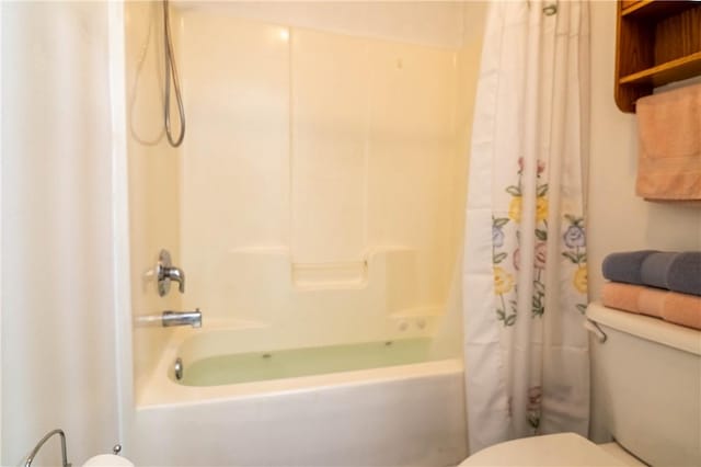 bathroom with shower / bath combination with curtain and toilet