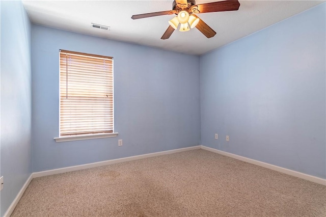 carpeted empty room with visible vents, baseboards, and ceiling fan