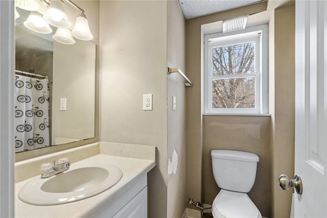 bathroom with toilet, vanity, and a shower with shower curtain