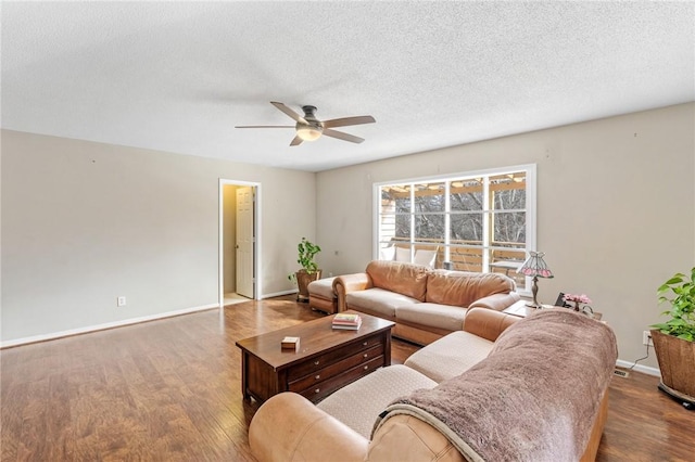 living area featuring ceiling fan, baseboards, a textured ceiling, and wood finished floors