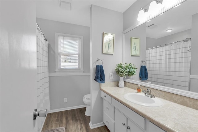 full bath with toilet, vanity, baseboards, and wood finished floors