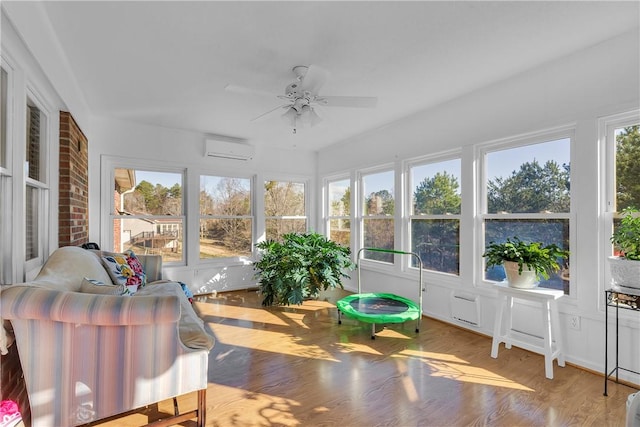 sunroom with an AC wall unit, plenty of natural light, and a ceiling fan