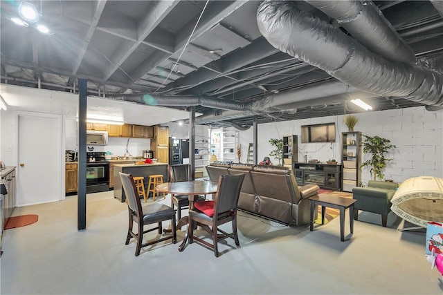 dining space featuring concrete block wall and concrete floors