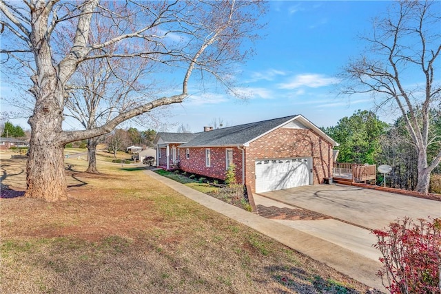 view of side of property with brick siding, a lawn, an attached garage, and concrete driveway