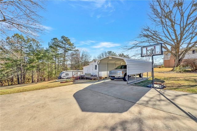 view of side of home with a detached carport, concrete driveway, and a yard