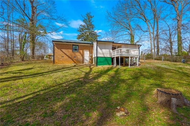 back of property featuring a yard, a fenced backyard, crawl space, a deck, and brick siding