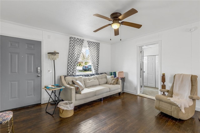 living area featuring hardwood / wood-style floors, a ceiling fan, baseboards, and ornamental molding