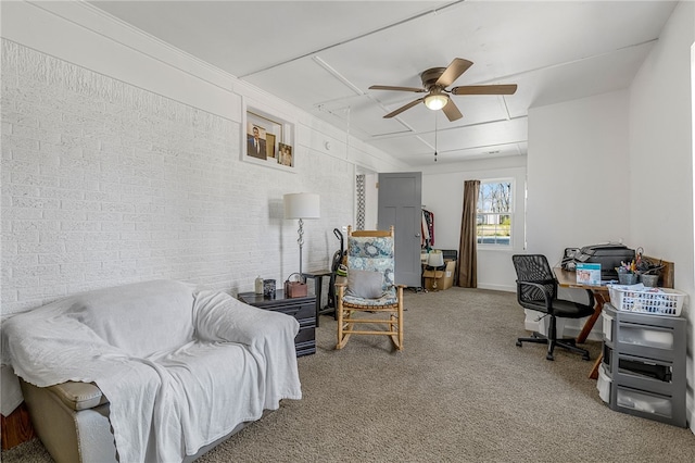 home office with brick wall, attic access, a ceiling fan, and carpet floors