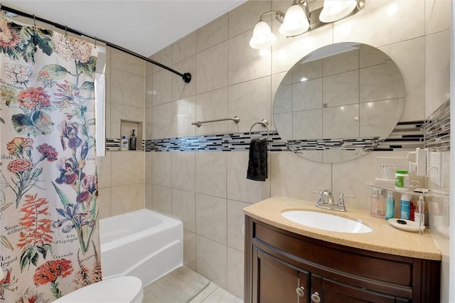 bathroom featuring vanity, tile walls, toilet, and shower / tub combo with curtain