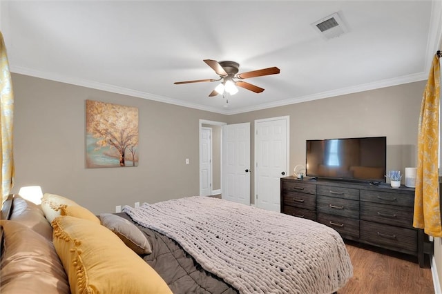 bedroom with visible vents, a ceiling fan, light wood-style flooring, and crown molding