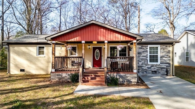 view of front of home featuring brick siding, a porch, roof with shingles, crawl space, and stone siding