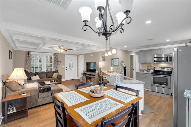 dining space featuring visible vents, coffered ceiling, recessed lighting, ceiling fan with notable chandelier, and light wood-type flooring