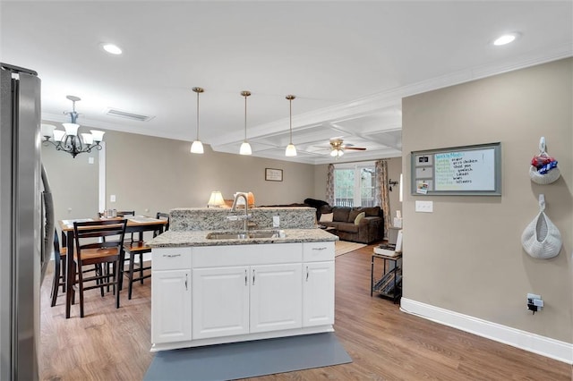 kitchen with visible vents, a sink, coffered ceiling, freestanding refrigerator, and light wood finished floors