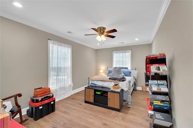 bedroom featuring baseboards, crown molding, and light wood-style floors