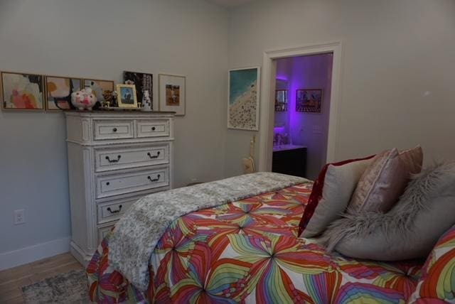 bedroom featuring baseboards and light wood finished floors