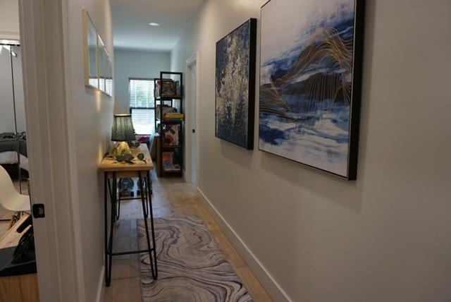 hall with baseboards and wood finished floors