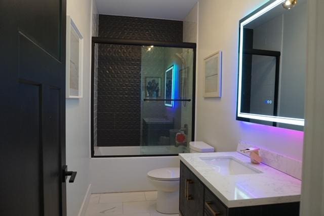 bathroom featuring vanity, toilet, and enclosed tub / shower combo