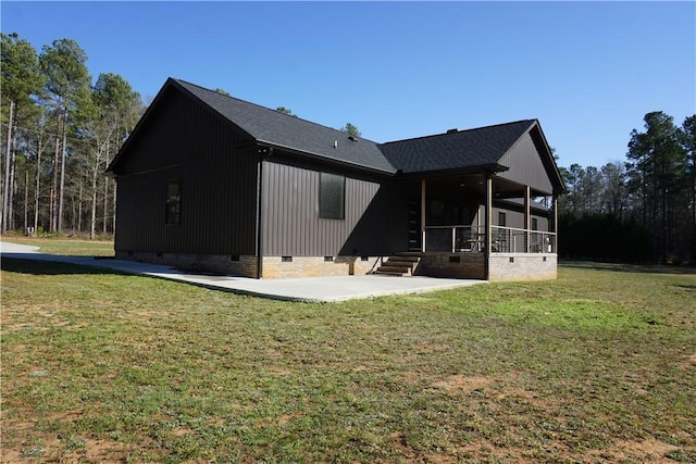 back of property featuring a patio, a yard, roof with shingles, and crawl space