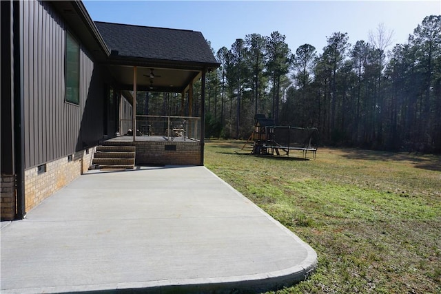 view of yard with a patio area, covered porch, a ceiling fan, and a trampoline