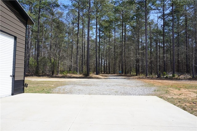 view of patio with a forest view and driveway