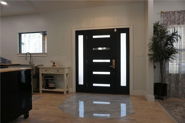 foyer with baseboards and light wood finished floors