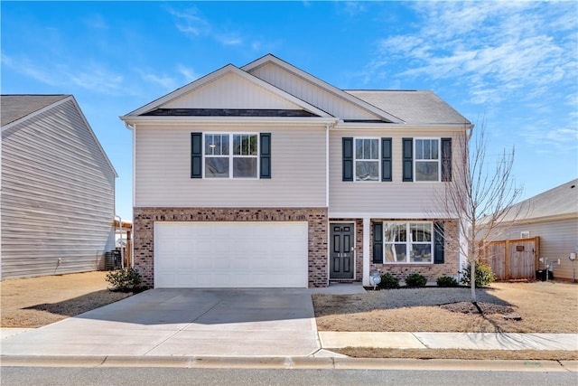 view of front of property featuring brick siding, driveway, a garage, and fence