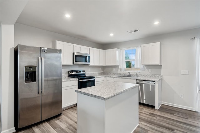 kitchen featuring a sink, stainless steel appliances, light wood-style floors, and visible vents