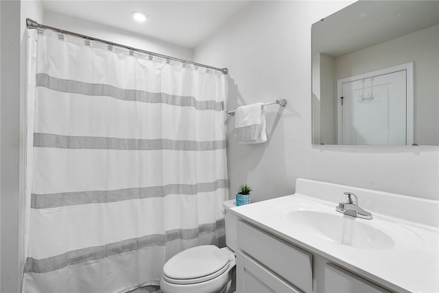 bathroom with curtained shower, toilet, and vanity