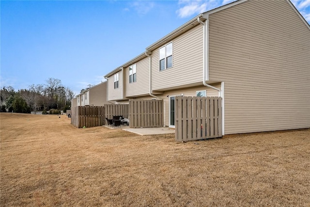 rear view of property with a lawn and fence