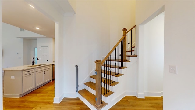 stairway with recessed lighting, visible vents, baseboards, and wood finished floors