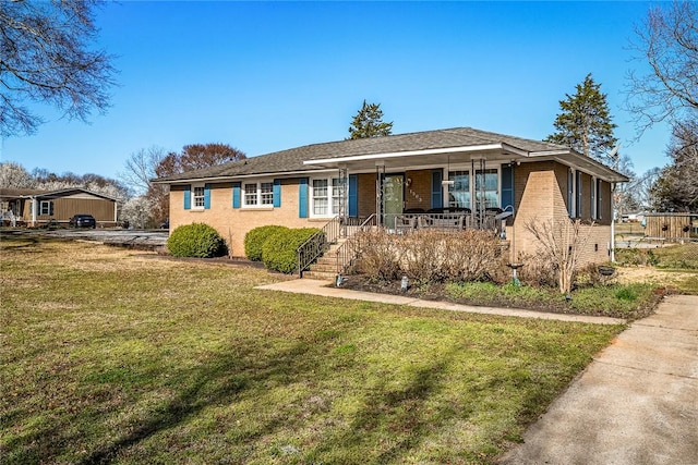 view of front of property with a front lawn, brick siding, and covered porch