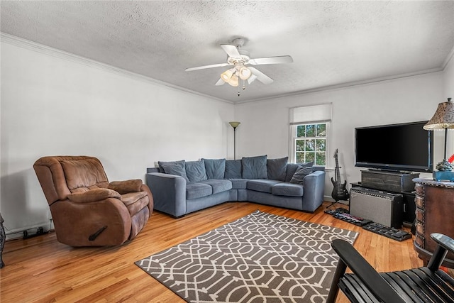 living area with a textured ceiling, crown molding, wood finished floors, and ceiling fan