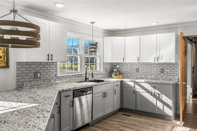 kitchen featuring light stone countertops, dark wood finished floors, a sink, gray cabinetry, and dishwasher