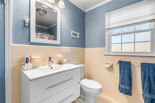 bathroom with visible vents, toilet, tile walls, crown molding, and vanity