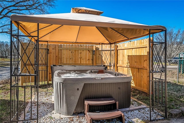 view of patio / terrace with a gazebo, central air condition unit, a hot tub, and fence