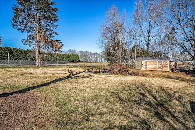 view of yard featuring a storage unit, an outbuilding, and fence