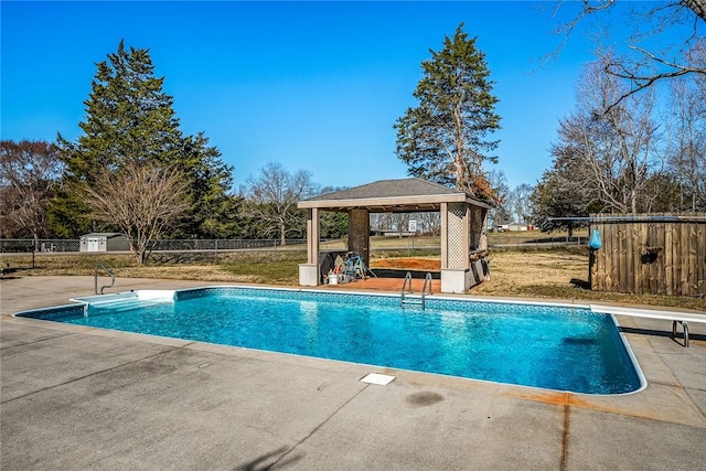 view of pool with a fenced in pool, fence, a gazebo, a patio area, and a diving board