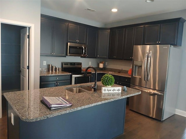 kitchen featuring visible vents, a sink, stone countertops, dark wood-style floors, and appliances with stainless steel finishes