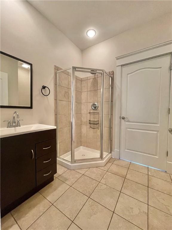 bathroom featuring tile patterned floors, a stall shower, and vanity