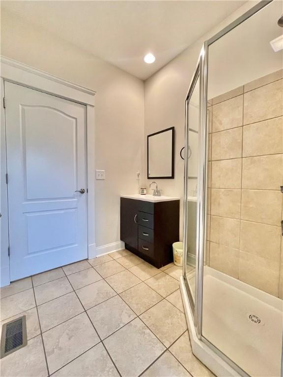 bathroom with tile patterned floors, visible vents, vanity, and a shower stall