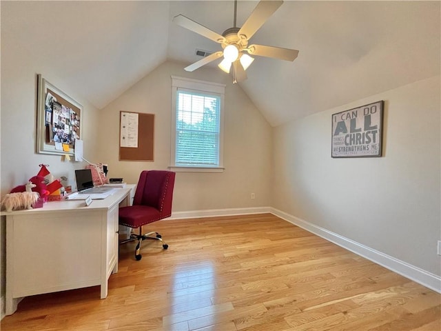 office area with visible vents, a ceiling fan, light wood finished floors, baseboards, and vaulted ceiling