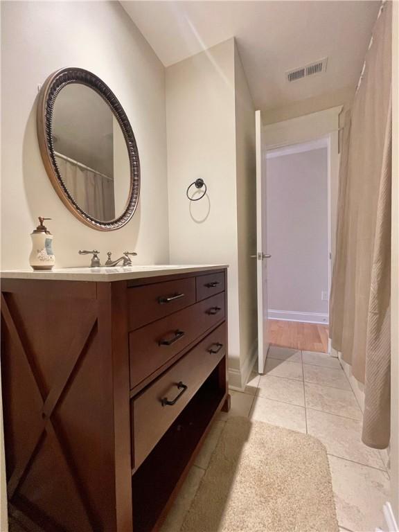 bathroom featuring tile patterned floors, visible vents, vanity, and baseboards