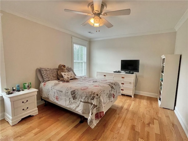 bedroom featuring visible vents, ornamental molding, light wood finished floors, baseboards, and ceiling fan