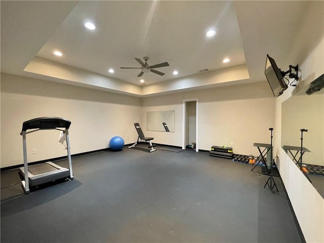 workout area featuring recessed lighting, baseboards, a raised ceiling, and a ceiling fan