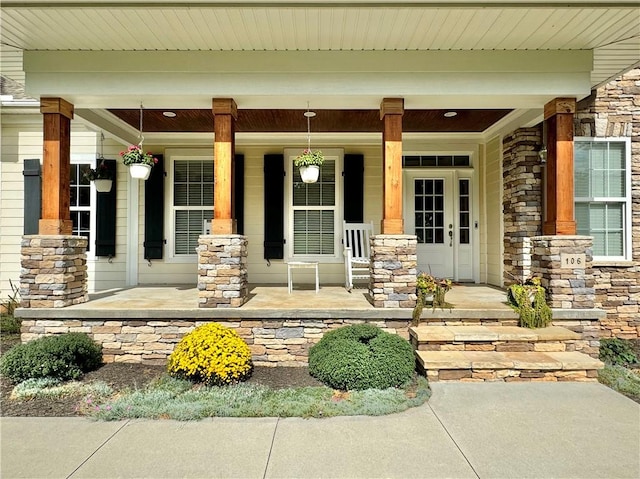 entrance to property featuring stone siding and covered porch