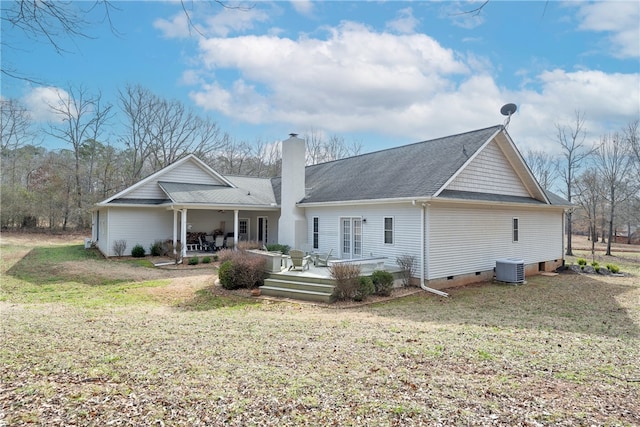 rear view of house featuring a lawn, a deck, central AC, crawl space, and a chimney